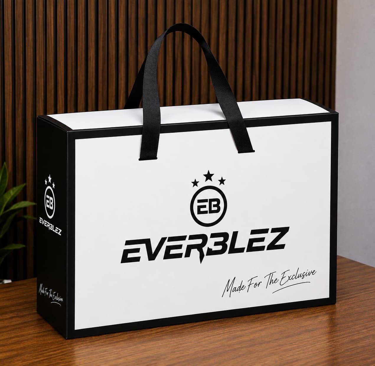 Everblez ivory gift box with black ribbon handles and the EB crest