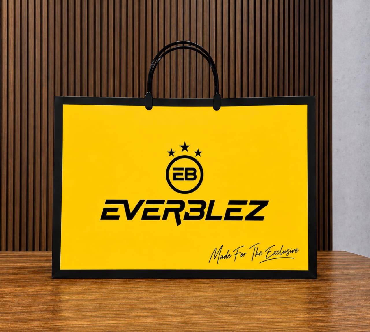 Everblez golden yellow shopping bag with black cord handles and the EB crest